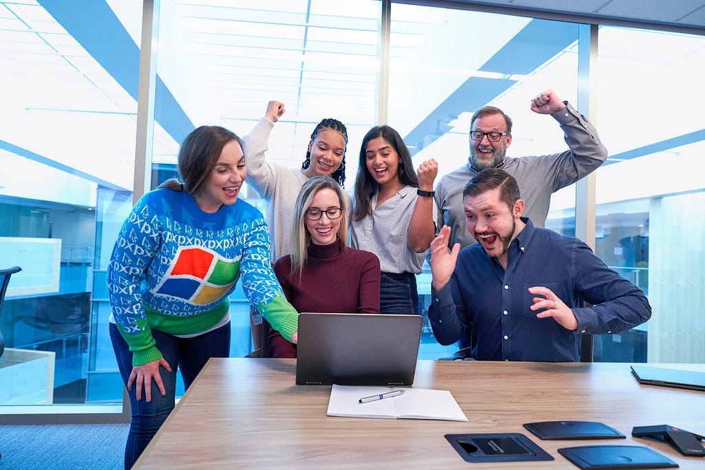 People cheering at a laptop